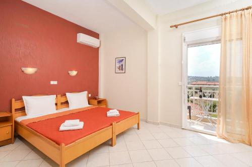 ein Schlafzimmer mit einem Bett und einem großen Fenster in der Unterkunft Studios Panagiota in Potos