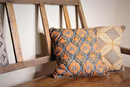 a pillow sitting on top of a wooden chair at Luxury Suites Vila Indonésia in Garopaba