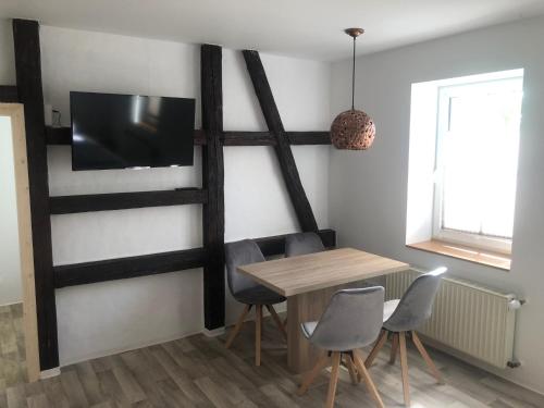 a dining room with a table and a television on a wall at Landgasthof Wetteraperle in Raila