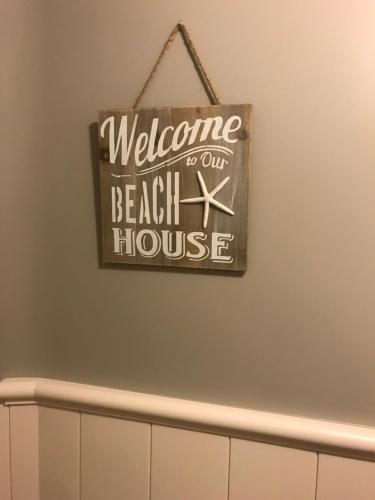 a welcome to our beach house sign on a wall at Cosy Apartment Near The Sea in Blankenberge