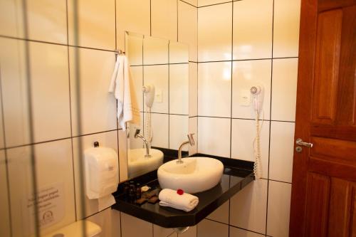 a bathroom with a sink and a mirror at Hotel Fazenda Da Chácara in Santana dos Montes