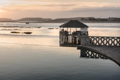 a pier with a gazebo on the water at La Sultana Oualidia in Oualidia