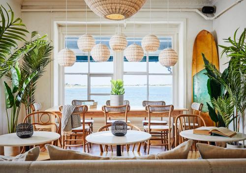 a restaurant with tables and chairs and a large window at Block Island Beach House in New Shoreham