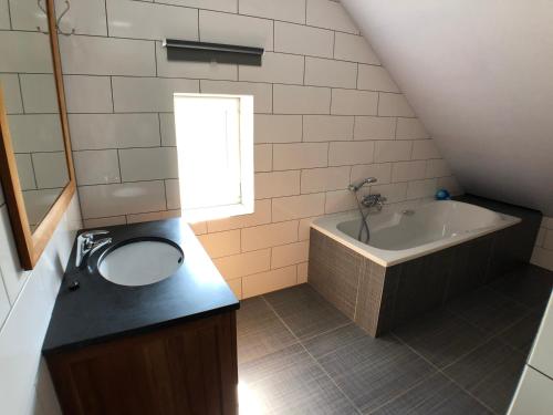 een badkamer met een wastafel en een bad bij De Holsterhoeve in Beringen