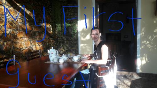 a man sitting at a table in a restaurant at Happy Horizon Home Stay in Ella