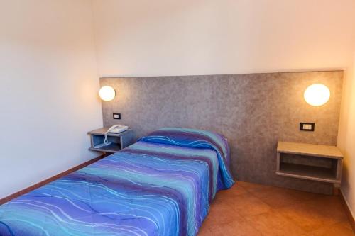 um pequeno quarto com uma cama e duas mesas em Autohotel Venezia em Mirano