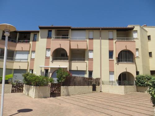 an apartment building with balconies and a fence at Appartement Carnon Plage in Carnon-Plage