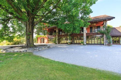 a house with a large tree in front of it at Tenuta La Quassa in Ispra