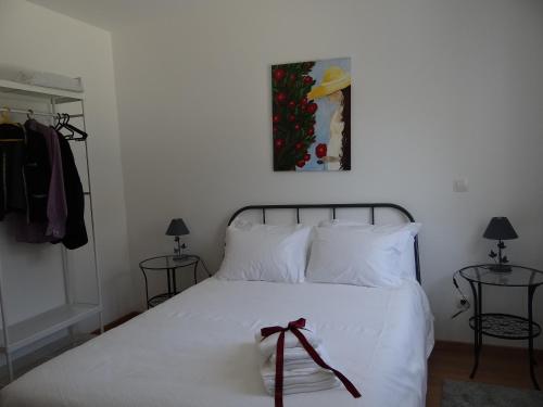 a bedroom with a white bed with a bow on it at Museu Casa Aleixo in Sernancelhe