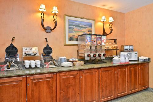 a kitchen with a counter with aasteryasteryasteryasteryasteryasteryasteryasteryastery at Ramada by Wyndham Kent Seattle Area in Kent