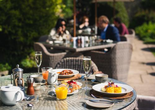 a table topped with plates of food and drinks at Barnsley House in Cirencester