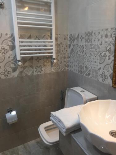 a bathroom with a toilet and a sink at HOTEL COMFORT in Kutaisi
