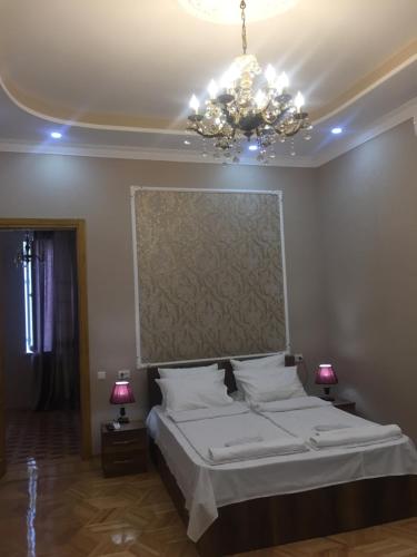 a bedroom with a large bed and a chandelier at HOTEL COMFORT in Kutaisi