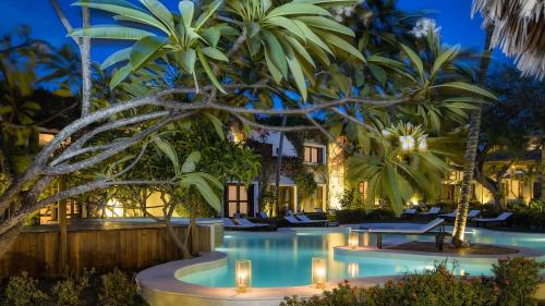 a resort with a pool at night with palm trees at My Blue Hotel in Jericoacoara