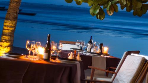 a table with wine bottles and glasses on the beach at My Blue Hotel in Jericoacoara