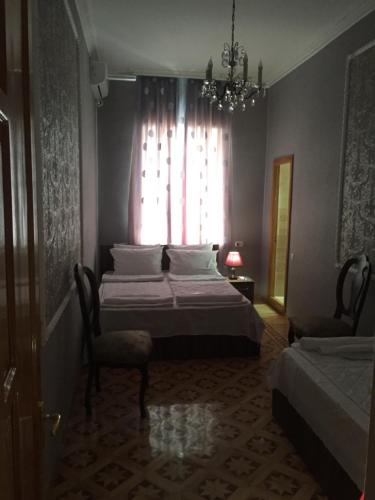 a bedroom with a bed and a window with a chandelier at HOTEL COMFORT in Kutaisi