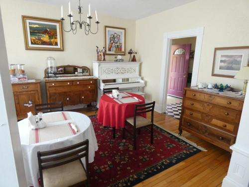 a dining room with a table and a white piano at LaCasa enShediac in Shediac