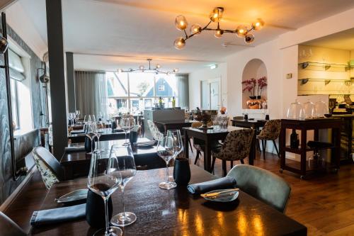 a restaurant with tables and chairs with wine glasses at B&B Hotel Rebecca in De Waal