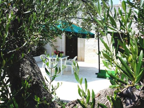 a patio with two white chairs and a table at Dimora Matarrese B&B Trulli in Alberobello
