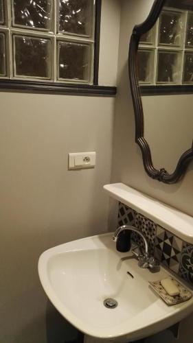 a bathroom with a white sink and a mirror at Résidence de Vaux in Nans-sous-Sainte-Anne