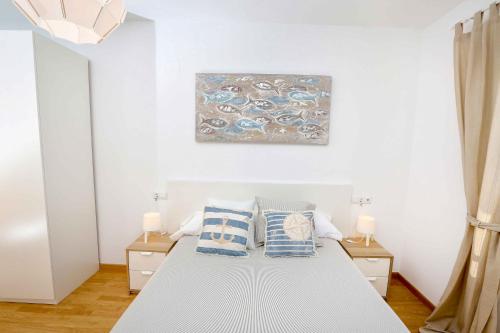 a bedroom with a bed with two pillows on it at Apartamento L&G Centro in Ayamonte