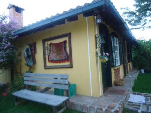 a bench sitting outside of a small house at Hostal Saint Mary´s Tababela in Tababela