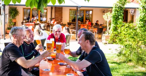 a group of people sitting at a table drinking beer at Gasthof Zur Burg in Ewattingen
