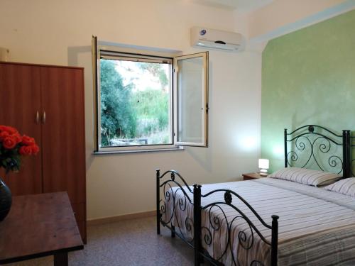 a bedroom with a bed and a window at Punto Verde B&B in Ardore Marina