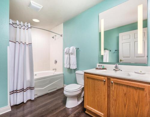 a bathroom with a toilet and a sink and a tub at Club Wyndham Tamarack in Wisconsin Dells