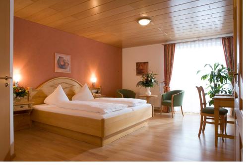 a bedroom with two beds and a table and chairs at Gasthof Zur Burg in Ewattingen