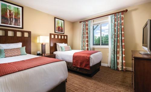 a hotel room with two beds and a window at Club Wyndham Tamarack in Wisconsin Dells