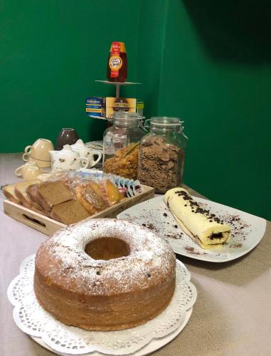 a table with a cake on a plate and other pastries at B&B "al Pesce Vela" in Albese Con Cassano
