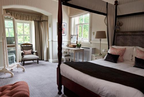 a bedroom with a large bed and a large window at Careys Manor Hotel & Spa in Brockenhurst