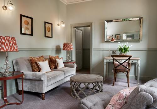 a living room with a couch and a table at Careys Manor Hotel & SenSpa in Brockenhurst