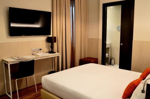 a hotel room with a bed and a desk and a television at Best Western Plus Soave Hotel in San Bonifacio