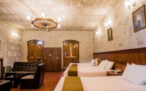 a hotel room with two beds and a couch at Majestad Hotel Boutique in Arequipa