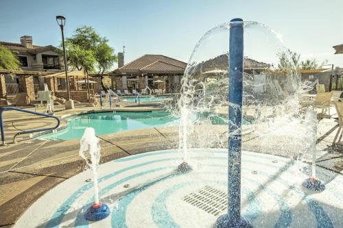 a fountain in the middle of a swimming pool at Raintree at Phoenix South Mountain Preserve in Phoenix