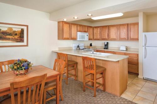 uma cozinha com uma mesa de madeira e uma cozinha com um lavatório em WorldMark Grand Lake em Monkey Island