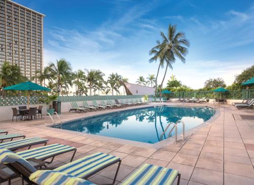 une piscine avec des chaises longues et un hôtel dans l'établissement Waikiki Marina Resort at the Ilikai, à Honolulu