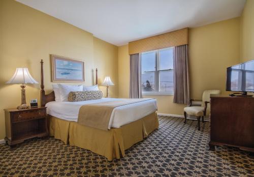 a hotel room with a bed and a flat screen tv at Club Wyndham Bay Voyage Inn in Jamestown