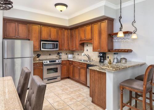 a kitchen with wooden cabinets and stainless steel appliances at Vino Bello Resort in Napa