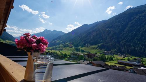 a vase of flowers on a balcony with a view of mountains at Fleckhof in Neustift im Stubaital