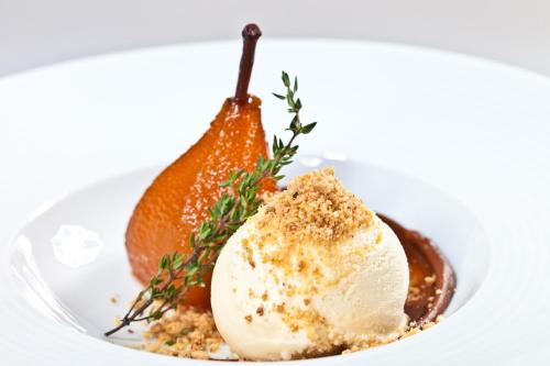 a plate with a scoop of ice cream and an orange at Hotel Panamby São Paulo in Sao Paulo