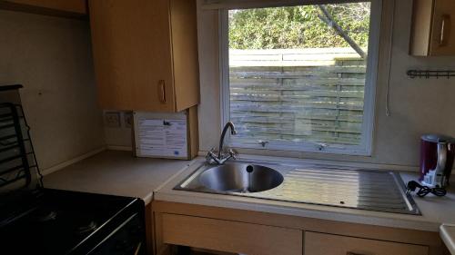 une cuisine avec un évier et une fenêtre dans l'établissement mobile home à saint Paul de vence, à Saint-Paul-de-Vence