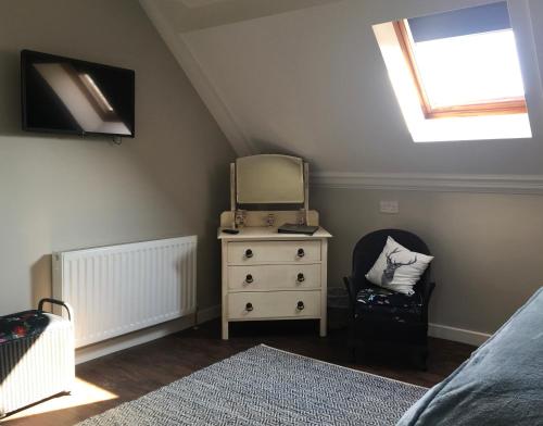 a bedroom with a dresser with a mirror and a bed at The Old School House in Haltwhistle