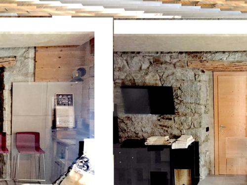 sala de estar con pared de piedra en Camera Milla - private room -T04416, en Temù