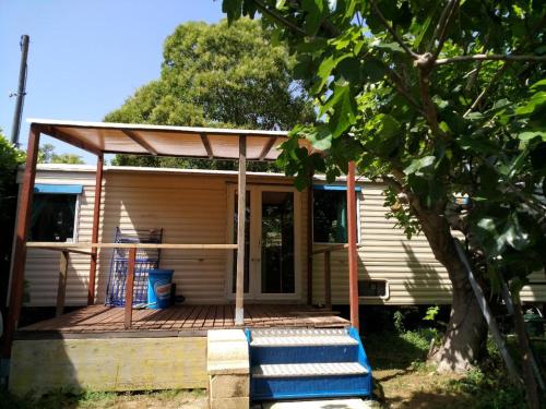 une petite maison avec un porche et une terrasse dans l'établissement mobile home à saint Paul de vence, à Saint-Paul-de-Vence