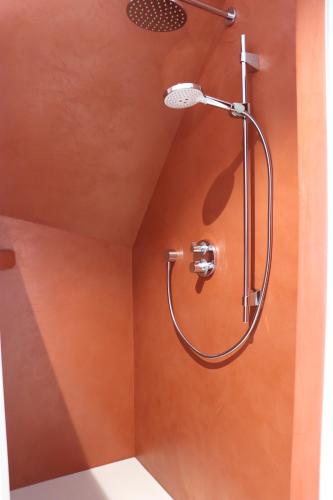 een douche met een douchekop in de badkamer bij In de gloria in Brakel
