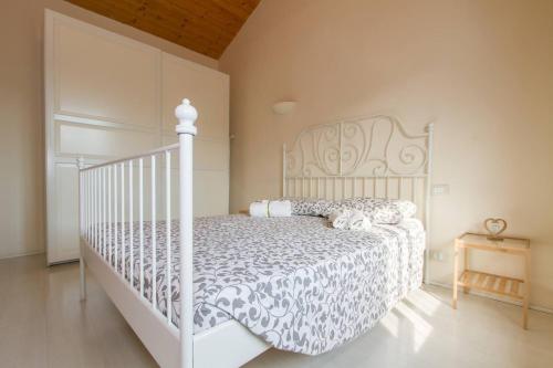 1 dormitorio con cama blanca y cuna blanca en Q21Apartment, en Bérgamo