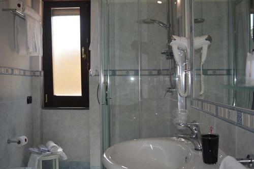 Costa Hotel في بومباي: حمام مع دش ومغسلة بيضاء